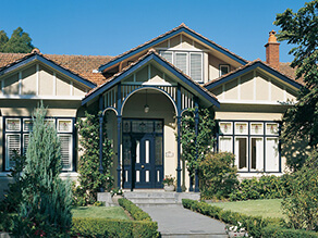 Front Cream Exterior with Blue Detailing and White Trims with Garden and Concrete Walkway Chimney